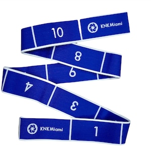 May include: Blue exercise resistance band with white numbers 1 through 10 printed on it. The band is marked with the text "KKN Miami" and a logo.