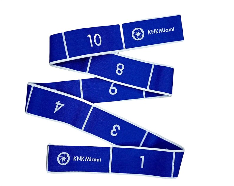 May include: Blue exercise resistance band with white numbers 1 through 10 printed on it. The band is marked with the text "KKN Miami" and a logo.