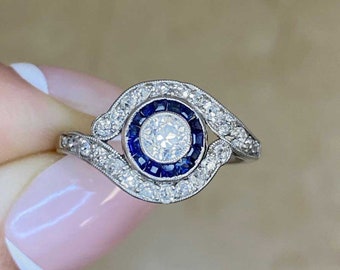 Antique Art Deco 0.22ct Old European Cut Diamond Ring with a Halo Sapphire Accent, Circa 1920. Platinum Ring.