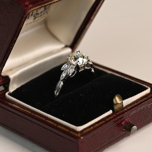 Oferta: Anillo de compromiso con diamante de talla europea antigua de 1 quilate. Detalle de diamante en forma de hoja. Elaborado a mano en platino con un elegante diseño de curva pronunciada.