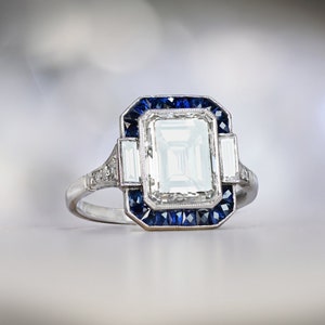 3.05ct Emerald Cut Diamond Engagement Ring with Halo Sapphire Accent. Platinum Ring.