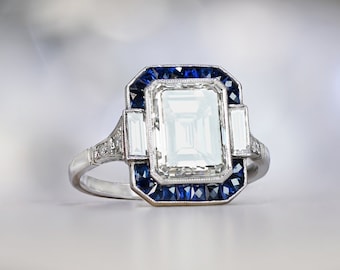 3.05ct Emerald Cut Diamond Engagement Ring with Halo Sapphire Accent. Platinum Ring.