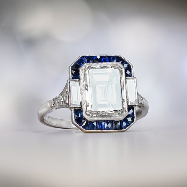 Bague de fiançailles diamant taille émeraude de 3,05 carats avec halo de saphirs. Bague en platine.