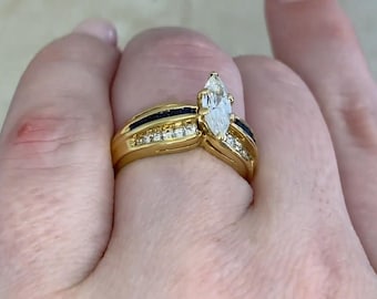 Anello antico vintage con diamante centrale taglio marquise da 0,65 carati. Anello con diamante incastonato a griffe. Anello con zaffiro taglio carré. Realizzato a mano in oro giallo 18 carati.