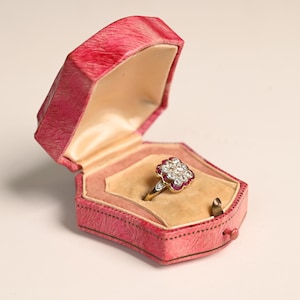 Antique Edwardian. 0.20center-ct Antique Cushion Cut Diamond Ring. Half Bezel Set Floral Ruby Ring, Circa 1905. Platinum on 18K Yellow Gold.