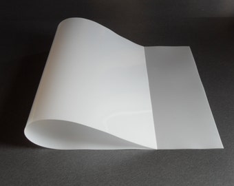 May include: A white, translucent sheet of plastic, folded in half, with a slight curve in the middle.