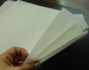 May include: A stack of white parchment paper, folded in half, with the edges of the paper visible.