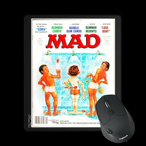 Könnte beinhalten: Eine schwarze Logitech-Maus neben einem Tablet, das ein Vintage-MAD-Magazin-Cover anzeigt. Das Cover zeigt drei Cartoonfiguren in einer Duschszene. Der Titel des Magazins steht in großen roten Buchstaben.