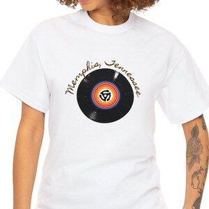 May include: White t-shirt featuring a black vinyl record graphic and the text "Memphis, Tennessee" in gold lettering.