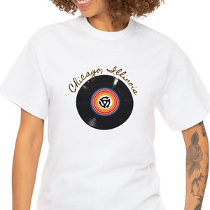 May include: White t-shirt featuring a black vinyl record graphic and the text "Chicago Illinois" in gold lettering.