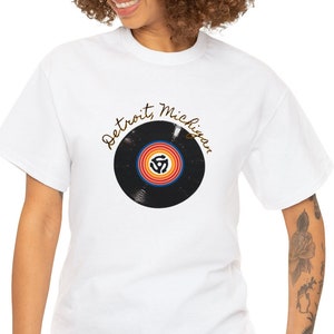 May include: White t-shirt featuring a black vinyl record graphic and the text "Detroit, Michigan" in gold script.