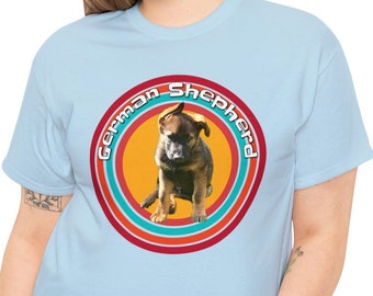 May include: A light blue t-shirt with a retro-style graphic of a German Shepherd puppy in a circle with the text "German Shepherd" around the circle.