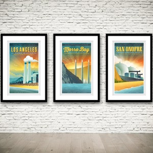 May include: Three framed posters with a retro-style design featuring illustrations of power plants in Los Angeles, Morro Bay, and San Onofre. Each poster has a yellow, orange, and blue color scheme with a white background.