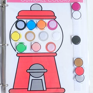 May include: A red gumball machine with a white lid and a white handle. The gumball machine has 12 different colored gumballs inside. The gumballs are yellow, blue, orange, pink, green, brown, white, gray, and black. The gumball machine is on a white background. The text "Gumball Colors" is at the top of the image.