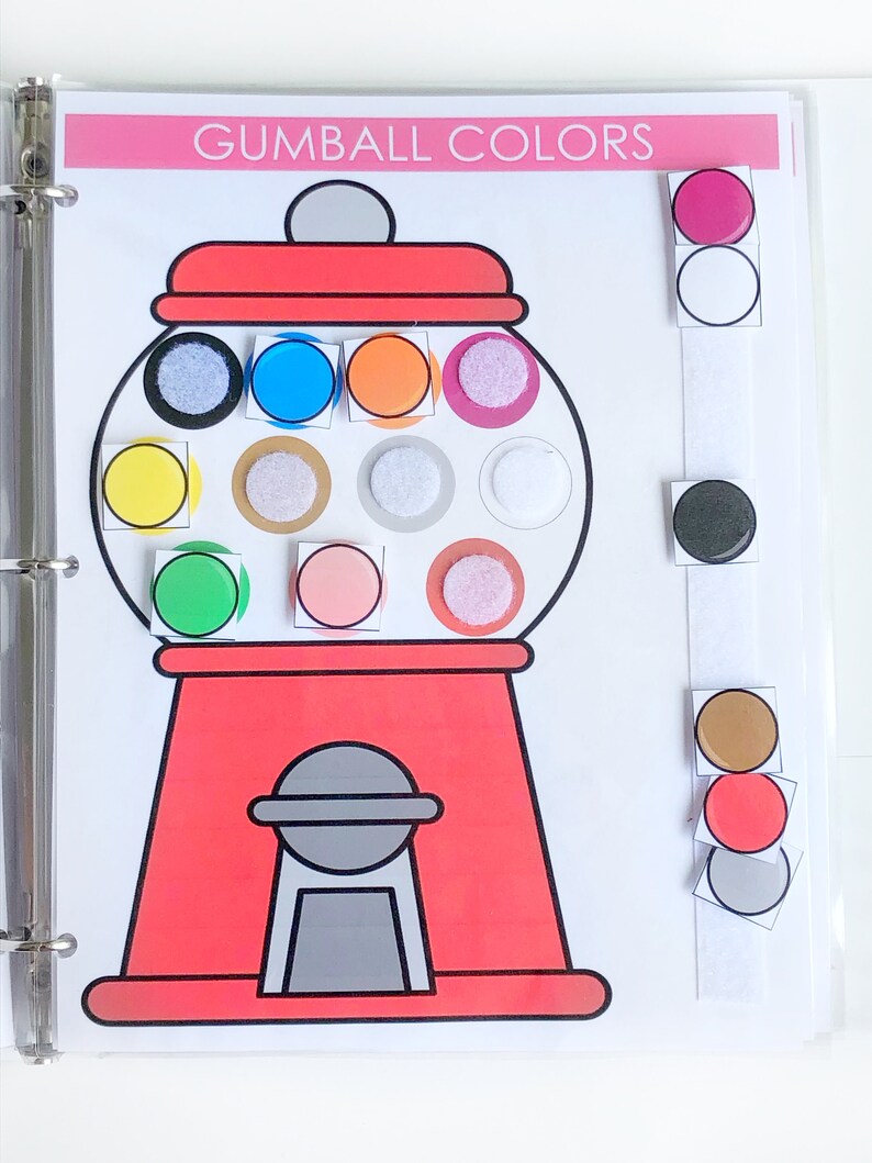 May include: A red gumball machine with a white lid and a white handle. The gumball machine has 12 different colored gumballs inside. The gumballs are yellow, blue, orange, pink, green, brown, white, gray, and black. The gumball machine is on a white background. The text "Gumball Colors" is at the top of the image.