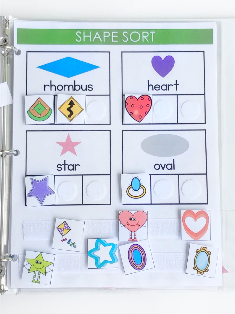 May include: A printable shape sort activity for kids. The page has four sections with different shapes: rhombus, heart, star, and oval. Each section has three spaces for children to place the corresponding shapes. The shapes are colorful and have fun designs.