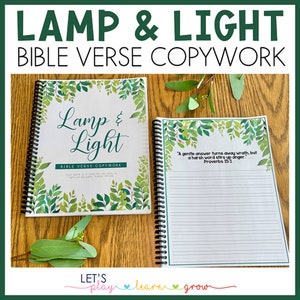May include: A green and white spiral bound notebook with the title "Lamp & Light Bible Verse Copywork" on the cover. The notebook has a green floral design and the text "A gentle answer turns away wrath, but a harsh word stirs up anger. Proverbs 15:1" on the inside page.