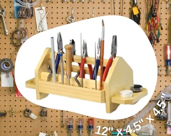 May include: A wooden tool rack with slots for holding tools. The rack is 12 inches by 4.5 inches and is made of solid wood. It is filled with various tools, including pliers, tweezers, and a small brush. The rack is mounted on a pegboard wall.