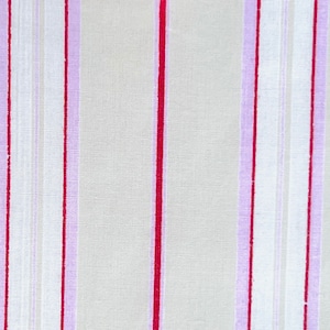 May include: A close-up of a fabric with a striped pattern. The fabric is white with thin red and purple stripes.