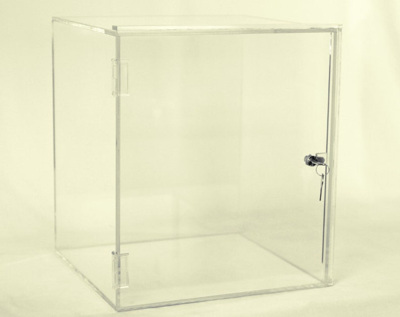 May include: A clear acrylic display case with a lock and key. The case has a hinged door and is made of thick, durable acrylic.