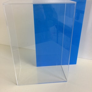 K&ouml;nnte beinhalten: Eine transparente Acryl-Vitrine mit einer blauen Acryl-R&uuml;ckwand. Die Vitrine ist leer und hat eine rechteckige Form.
