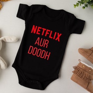 May include: Black baby onesie with red text that reads "NETFLIX AUR DOODH".