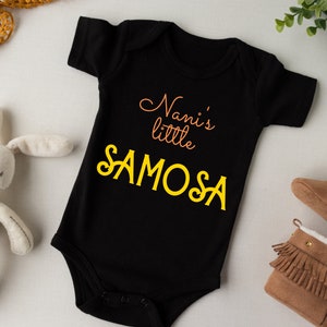 May include: Black baby onesie with the text "Nani's little SAMOSA" in yellow and orange lettering.