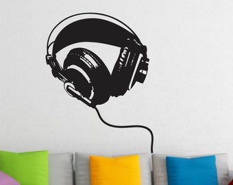 May include: Black and white silhouette of a pair of headphones with a cord extending from the bottom. The headphones are on a white wall.