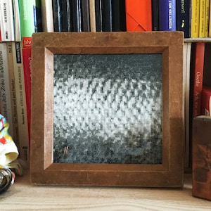 Könnte beinhalten: Ein gerahmtes Schwarzweißbild mit einem Gittermuster. Der Rahmen ist aus Holz und hat eine dunkelbraune Oberfläche.