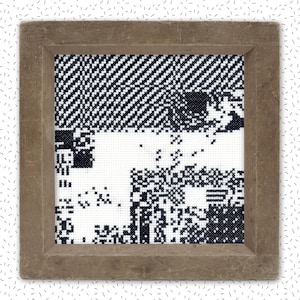 May include: A framed black and white pixelated image with a geometric pattern. The frame is brown wood.