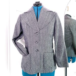 May include: A gray and white herringbone blazer with a notched collar, three button closure, and two patch pockets.