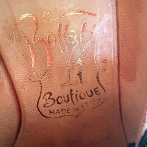 Op de afbeelding: Close-up van de binnenzool van een schoen. De lichtbruine zool heeft de naam "Bollati" in gouden letters. Daaronder staan in zwarte letters de woorden "Boutique" en "Made in Italy".