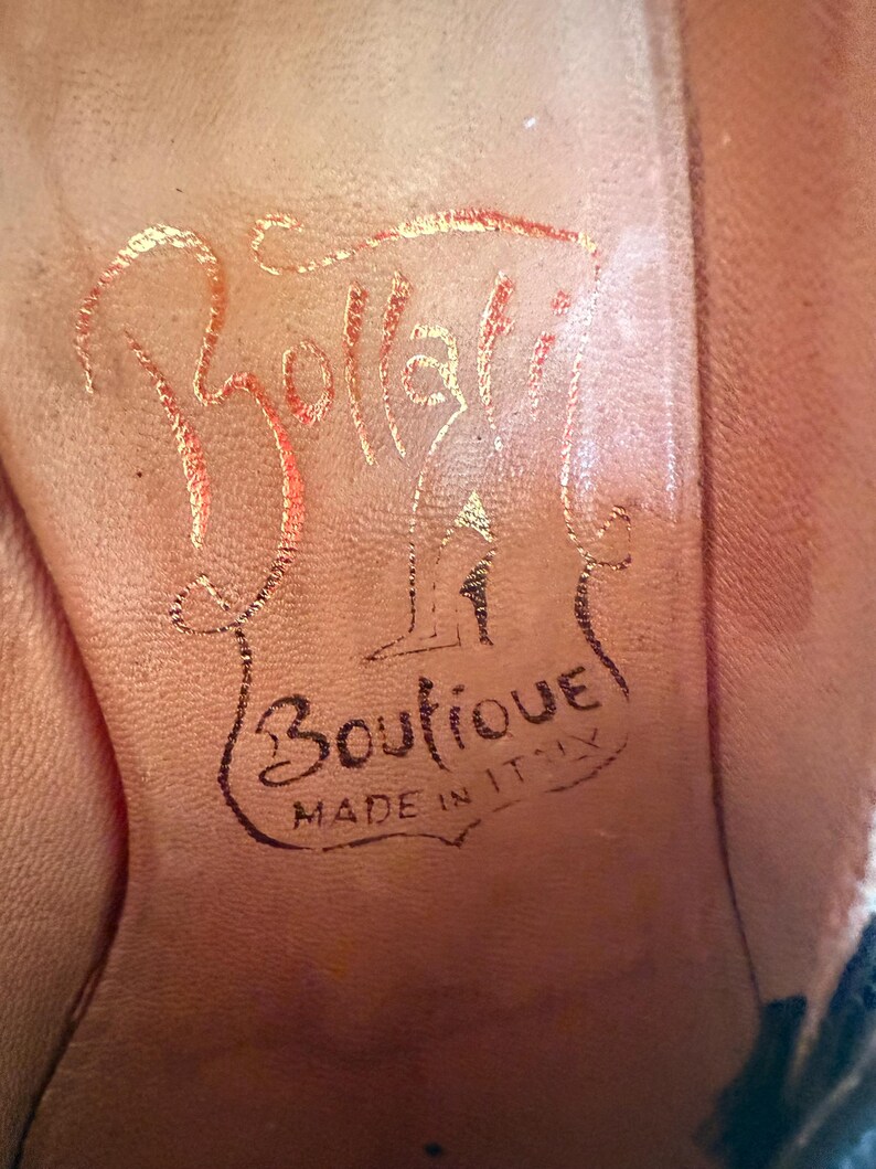 Op de afbeelding: Close-up van de binnenzool van een schoen. De lichtbruine zool heeft de naam "Bollati" in gouden letters. Daaronder staan in zwarte letters de woorden "Boutique" en "Made in Italy".
