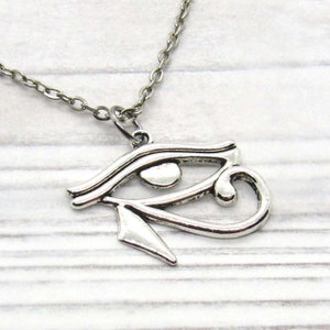 Puede incluir: Collar de plata con un colgante de Ojo de Horus. El colgante es una representaci&oacute;n detallada del s&iacute;mbolo egipcio antiguo.