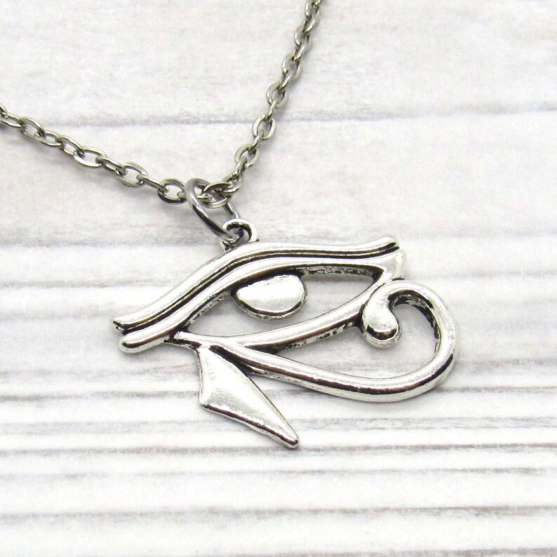 Puede incluir: Collar de plata con un colgante de Ojo de Horus. El colgante es una representaci&oacute;n detallada del s&iacute;mbolo egipcio antiguo.