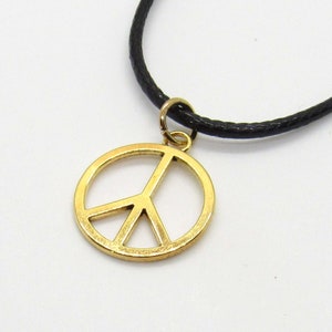 May include: A gold peace sign pendant necklace with a black cord.