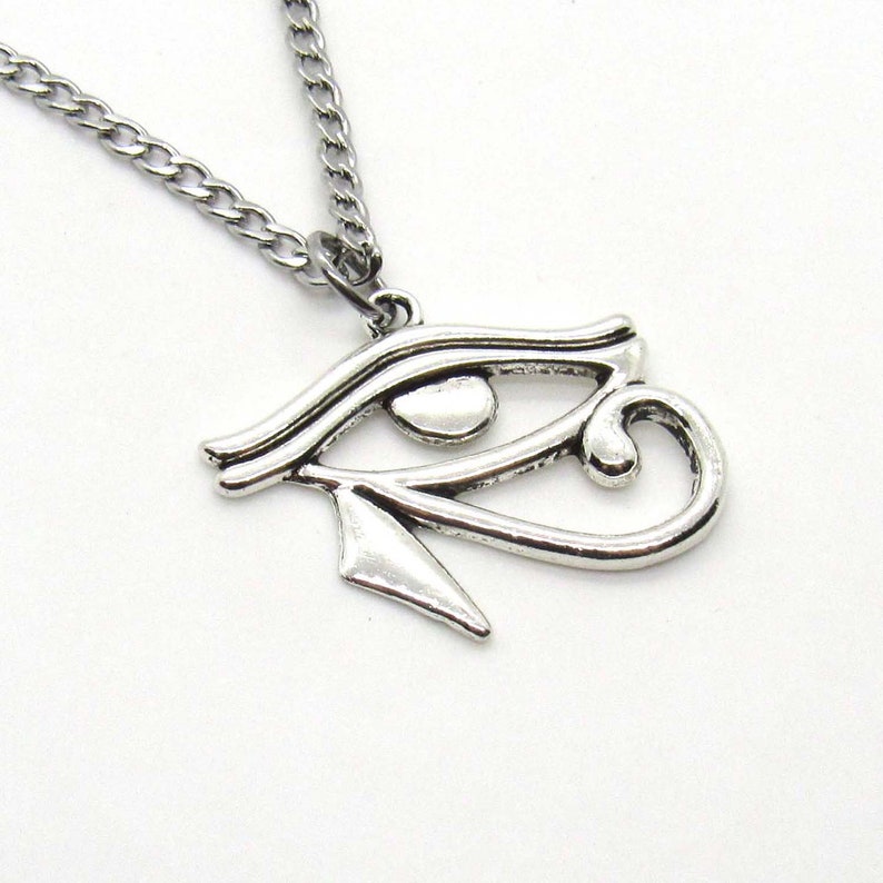 Puede incluir: Collar de plata con un colgante de Ojo de Horus. El colgante es una representaci&oacute;n detallada del s&iacute;mbolo egipcio antiguo.