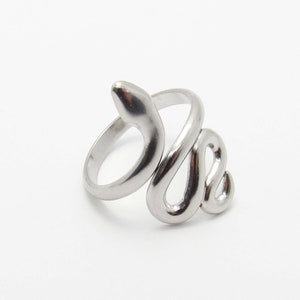 May include: A silver snake ring with a coiled design. The ring is made of metal and has a smooth finish.