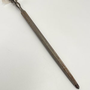 May include: A silver-plated knife sharpener with a steel blade. The blade is slightly rusted.