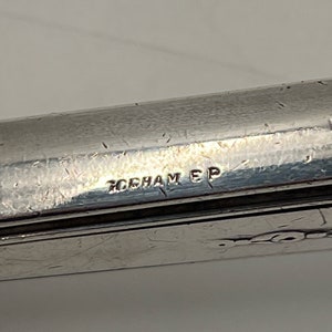 May include: Close-up of a silver-plated utensil with the inscription "GORHAM EP" on the bottom.