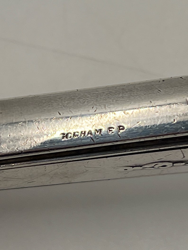 May include: Close-up of a silver-plated utensil with the inscription "GORHAM EP" on the bottom.