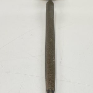 May include: A silver metal knife sharpener with a diamond-shaped tip and a textured surface.