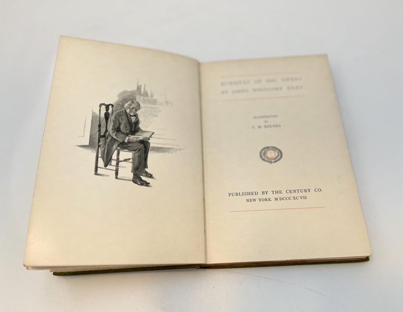 Puede incluir: Un libro abierto con una ilustraci&oacute;n en blanco y negro de un hombre sentado en una silla y leyendo. La p&aacute;gina del t&iacute;tulo del libro dice "The Mystery of the Seaport by James Whitcomb Riley". El libro fue publicado por The Century Co. en Nueva York en 1907.