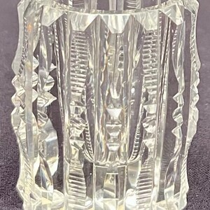 May include: A clear glass jar with a cut glass design. The jar has a cylindrical shape and a wide mouth.