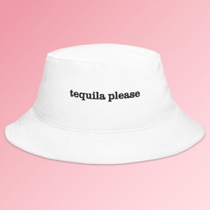 May include: White bucket hat with the text "tequila please" embroidered in black.