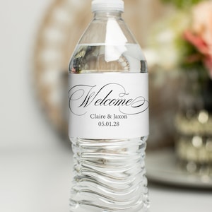 Könnte beinhalten: Eine weiße Wasserflasche mit einem schwarz-weißen Etikett, auf dem "Welcome Claire & Jaxon 05.01.28" steht.