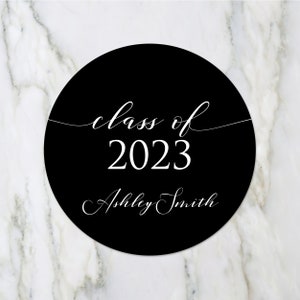 May include: Black and white circle sticker with the text "class of 2023" and "Ashley Smith" in a cursive font.