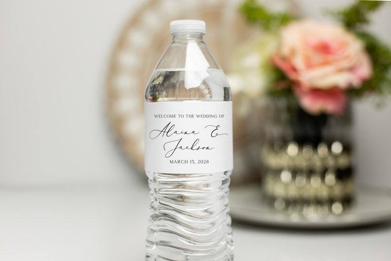 May include: A white water bottle label with black text that reads "Welcome to the wedding of Alaina & Jackson March 15, 2028".