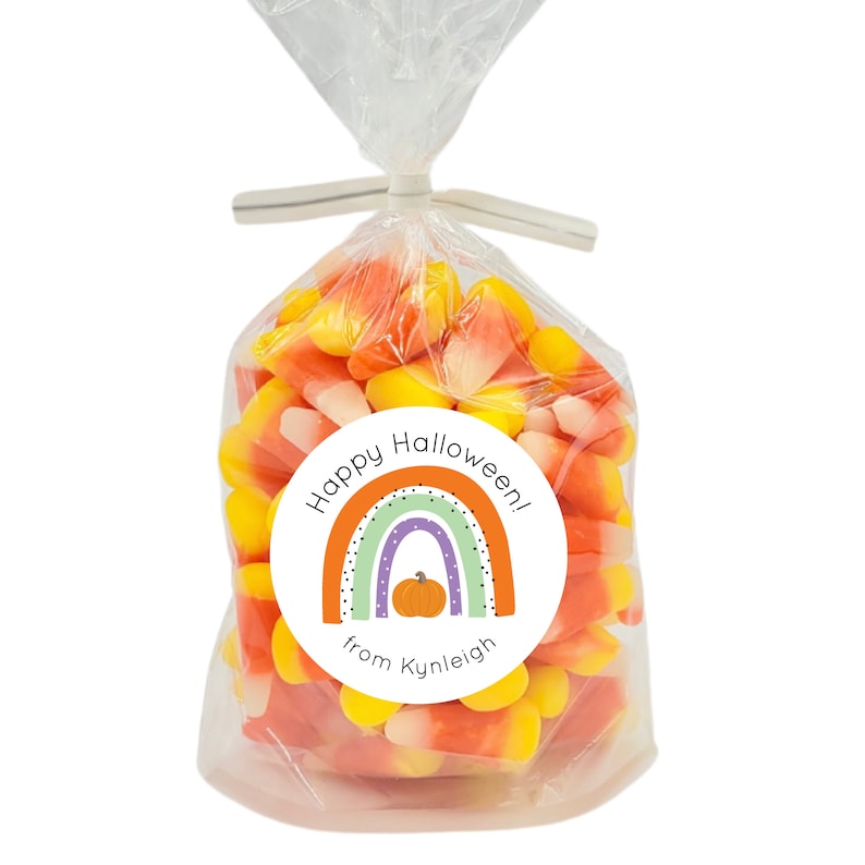 May include: A white circle sticker with a rainbow, a pumpkin, and the text "Happy Halloween! from Kynleigh".