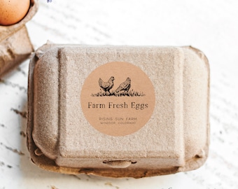 May include: A brown paper sticker with a black and white illustration of two chickens. The sticker says "Farm Fresh Eggs" with the text "Rising Sun Farm Windsor, Colorado" below the illustration.